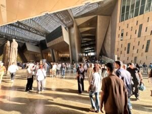 Visitors walking through the large modern atrium of the Grand Egyptian Museum near Giza