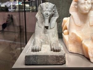 Granite sphinx of King Thutmose III from Karnak, Dynasty 18, displayed beside a travertine sphinx at the Grand Egyptian Museum in Giza