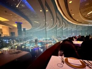 Nighttime Cairo skyline and Nile River seen through curved glass from an elegant restaurant table