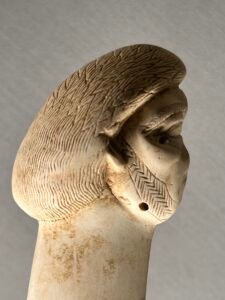 Carved ancient Egyptian female head in profile with a detailed braided or patterned wig at the Egyptian Museum in Cairo