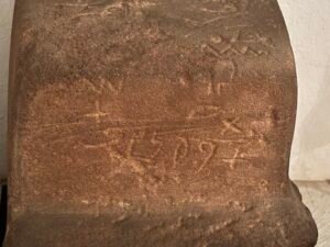 Close view of faint ancient incised lines and graffiti on a brown stone surface at the Egyptian Museum in Cairo