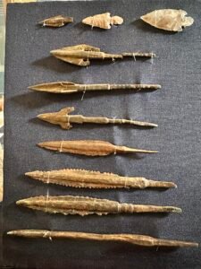Museum display of ancient Egyptian flint arrowheads and copper-alloy spear or arrow points, including barbed and serrated forms, Egyptian Museum in Cairo
