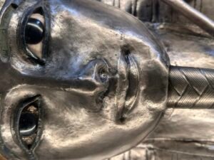 Close-up of Pharaoh Psusennes I's silver coffin, JE 85917, showing the polished silver face, inlaid eyes and modeled lips at the Egyptian Museum in Cairo