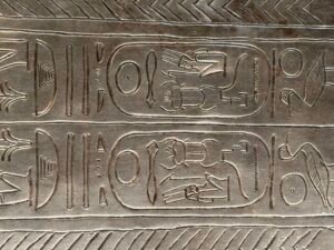 Close-up of paired royal cartouches and surrounding hieroglyphs engraved on the silver coffin of Pharaoh Psusennes I, JE 85917, Egyptian Museum in Cairo
