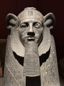 Close frontal view of Pharaoh Amenemhat III on the grey granite Tanis sphinx, JE 15210 / CG 394, showing the lion mane, royal beard and weathered face in the Egyptian Museum in Cairo