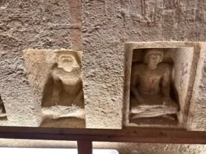 Two recessed stone carvings of seated human figures inside the Tomb of Meresankh III on the Giza Plateau