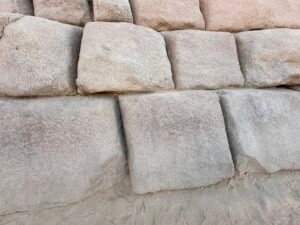 Close-up of large pink-gray granite casing blocks in the lower courses of the Pyramid of Menkaure on the Giza Plateau