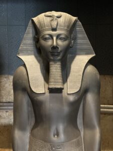Close-up of Pharaoh Thutmose III on greywacke striding statue Luxor Museum J.2 / CG 42054 / JE 36927, showing the nemes headdress, uraeus and ceremonial beard