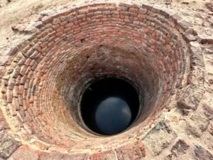View down the red-brick shaft of the Roman well at Tell Basta, ancient Bubastis, with water visible at the bottom in Zagazig, Egypt