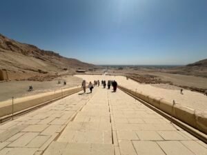 View down the central ramp of Hatshepsut's mortuary temple at Deir el-Bahari toward the desert plain and Nile Valley on Luxor's west bank