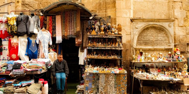 Colorful souvenir and clothing stall in a Cairo market, illustrating shopping and street-vendor interactions in Egypt