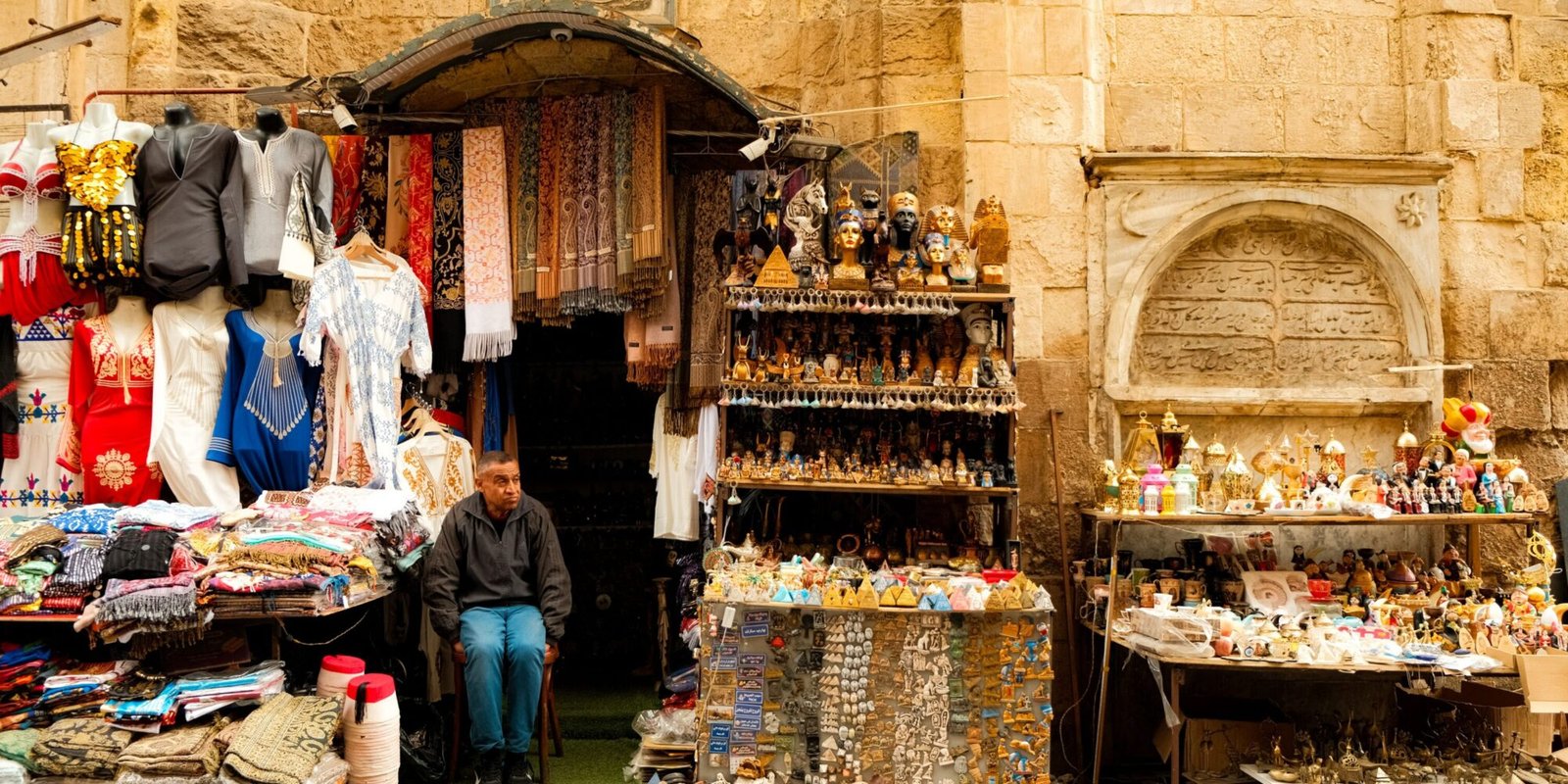 Colorful souvenir and clothing stall in a Cairo market, illustrating shopping and street-vendor interactions in Egypt