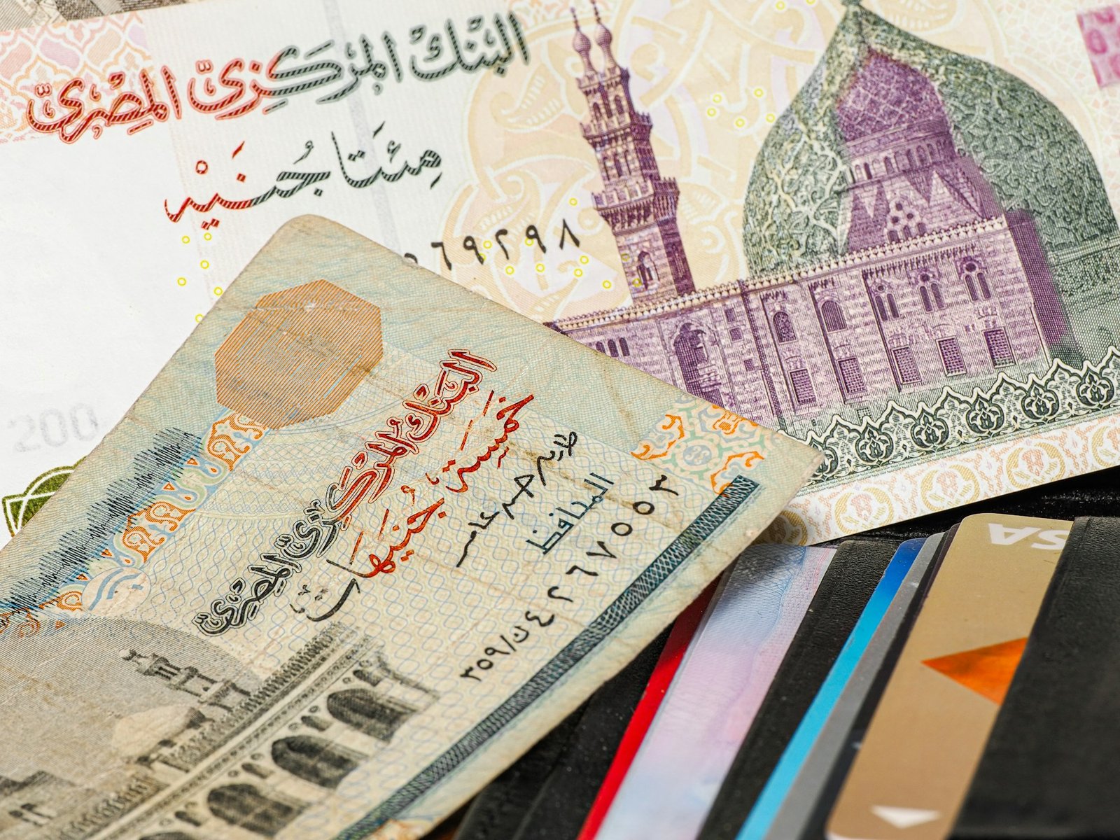 Egyptian pound banknotes beside payment cards, illustrating cash and card use while traveling in Egypt