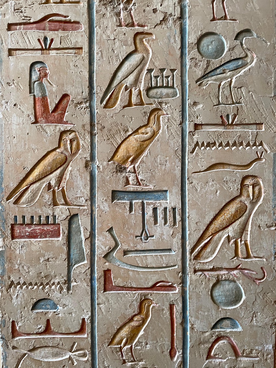 Painted ancient Egyptian hieroglyphs showing birds, human figures and phonetic signs